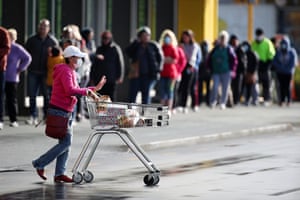 Shoppers queue outside a supermarket in Auckland after New Zealand’s dream run of 102 days without locally transmitted coronavirus ended
