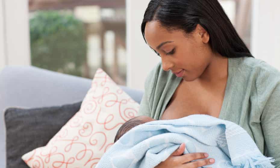 Woman holds baby son in blanket.