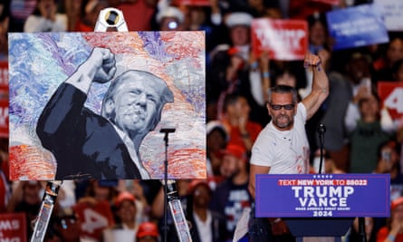 Artist Scott LoBaido next to the portrait of Trump he painted on stage during a rally at Nassau Veterans Memorial Coliseum, in Uniondale, New York.