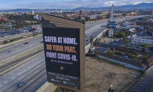 A sign near a Los Angeles freeway encourages people to stay at home to slow the spread of coronavirus.