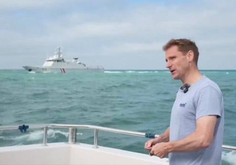 Chris Philp near a French naval ship from where shots were fired.