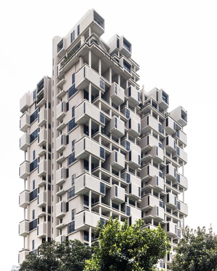 An exterior view of an apartment building with many protruding balconies and open exterior walkways.
