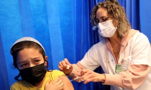 A health worker administers a dose of the Pfizer-BioNTech Covid-19 vaccine to a child at the Clalit Health Services in the central Israeli city of Modiin.