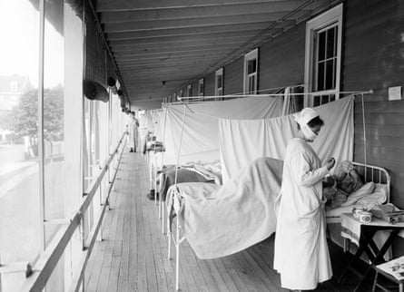 A nurse checking on a patient at the Walter Reed hospital flu ward during the influenza pandemic in 1918.