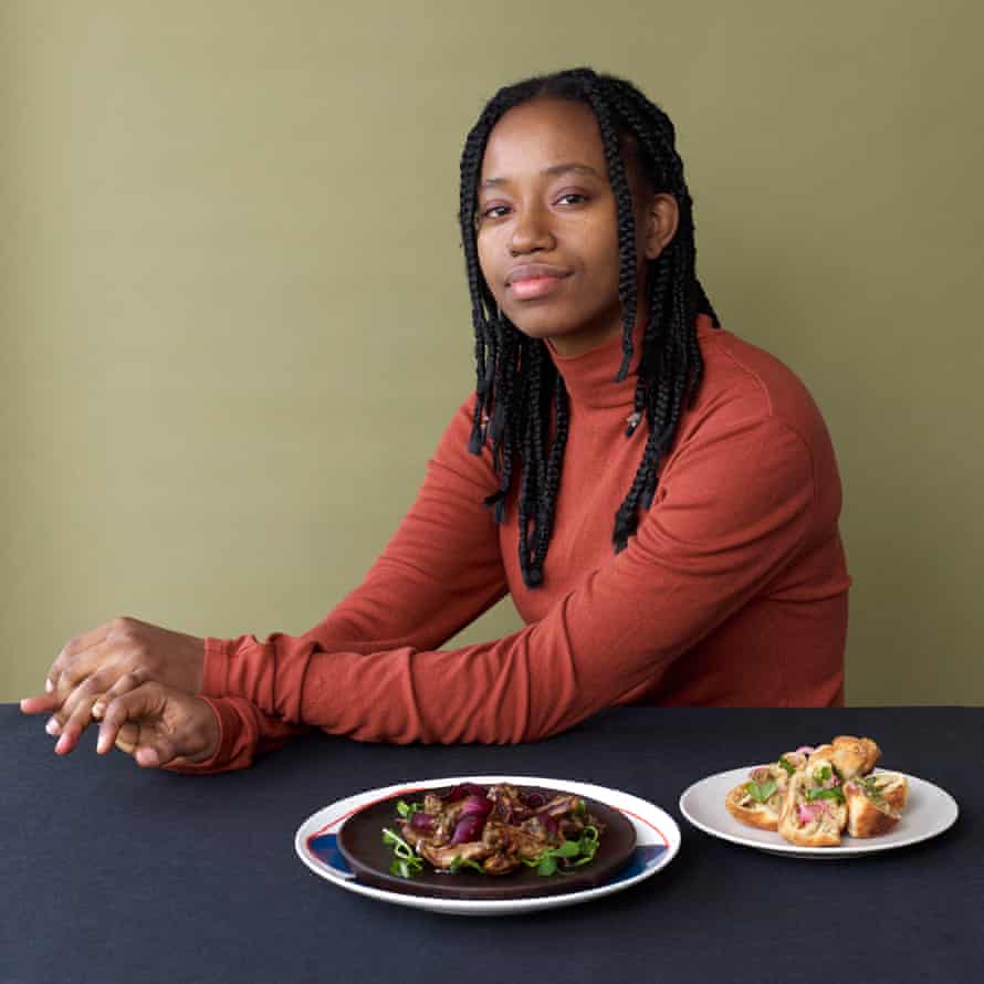 Observer Food MonthlyCaribbean feature - Jamaican chef Danai Moore with her dishes Roasted Spiced Jerusalem Artichokes - Chargrilled Spring Onion Chimichurri - Pea Shoots &amp; Heritage Carrots. (on brown plate) Ackee &amp; ‘Saltfish’ stuffed fried dumplings - Pickled Red Onions. (on cream plate)