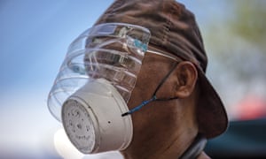 A man wears a makeshift mask made out of a styrofoam cup and a face shield made out of a plastic bottle in Manila on Monday.