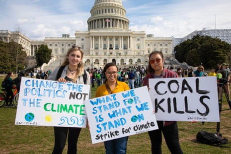 people hold signs calling attention to climate change