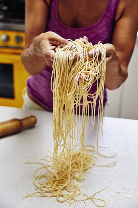 Cookbook author Silvia Colloca holding a tangle of homemade tagliolini.