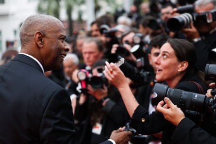 Denzel Washington speaks with press on the red carpet at the Highest 2 Lowest premiere in Cannes.