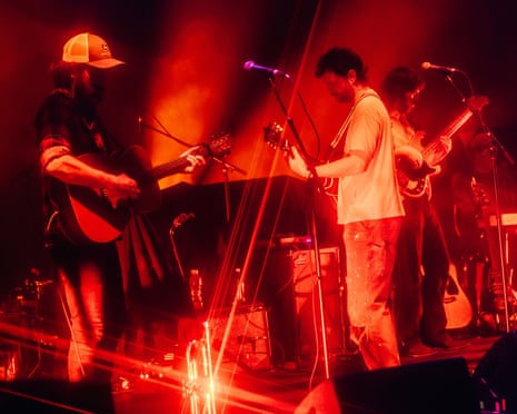 Three guitarists performing on stage