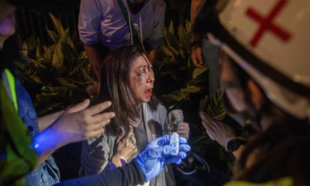 A woman who was beaten after removing anti-government posters is treated by medics.