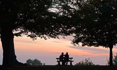 A couple sits on a bench.