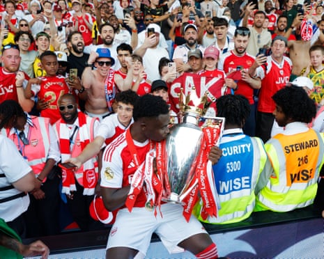 Bukayo Saka kisses the trophy.