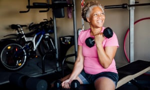 Black woman lifting weights in garage