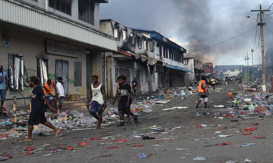 People walk through the Chinatown district of Honiara after days of violence.
