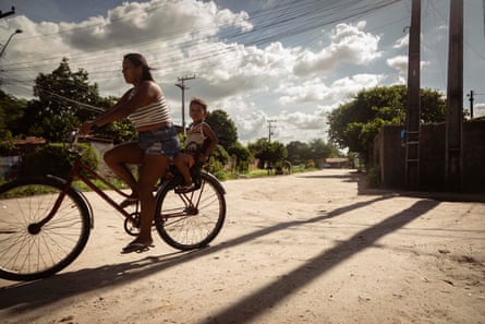 Two people on bikes cycle along a street