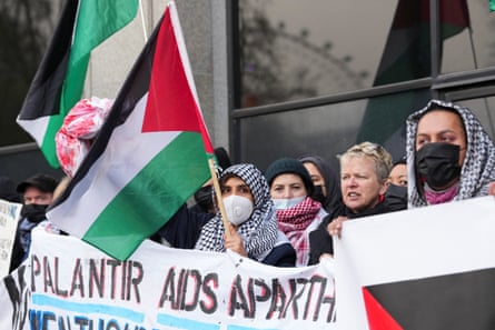 NHS workers protesting in support of Palestinians hold a banner criticising Palantir