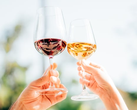 A close-up shot of a couple clinking wine glasses