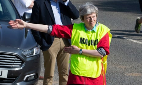 Theresa May helps as a marshal at the Maidenhead 10-mile run in Berkshire over Easter.