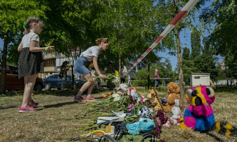 A woman lays flowers in a small memorial with toys and flowers in the location of two victims killed by Russian missiles strikes over Kyiv, Ukraine, on 1 June 2023.