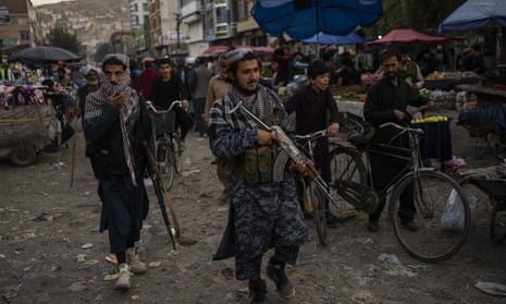 Taliban fighters patrol a market in Kabul's Old City