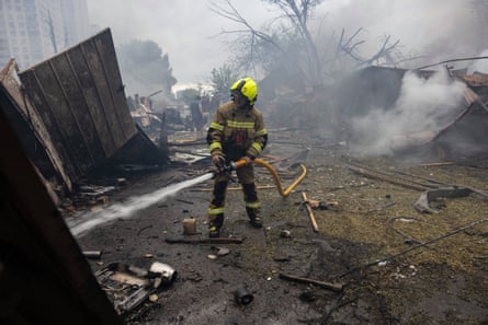 A firefighter tackles a blaze that engulfed a residential building in Kyiv.