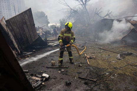 A firefighter works on a fire at the scene of an attack as Russian missiles and drones strike Kyiv overnight on Monday.