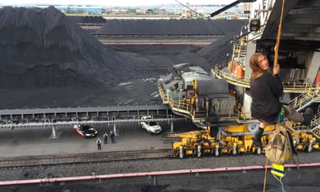 Activist abseils from coalmining machinery as police look on from the ground