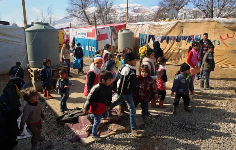 Children leave a makeshift school at the end of lessons at a camp in the Bekaa