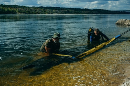 Archeologists move a boat hollowed out from a single tree trunk, which was found underwater just off Khortytsia island.