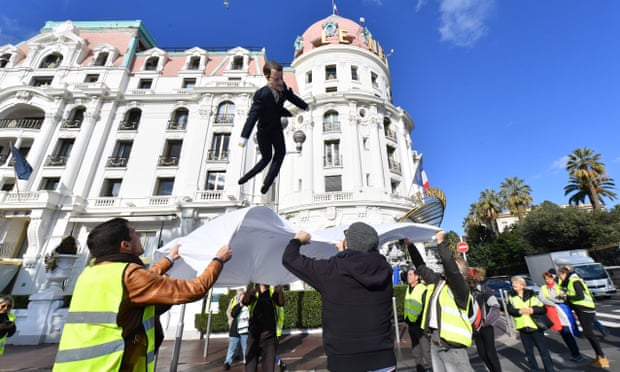 An effigy of Emmanuel Macron is thrown into a sheet during a gilets jaunes protest in Nice.
