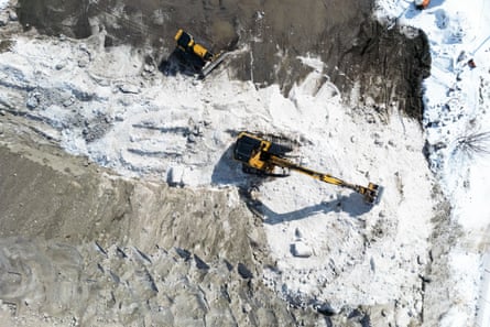 An overhead shot of a power shovel moving piles of snow
