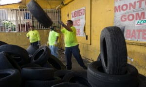 Employees with the municipal government collect used tires on 7 August 2016 in the Rio Piedras section of San Juan, Puerto Rico.