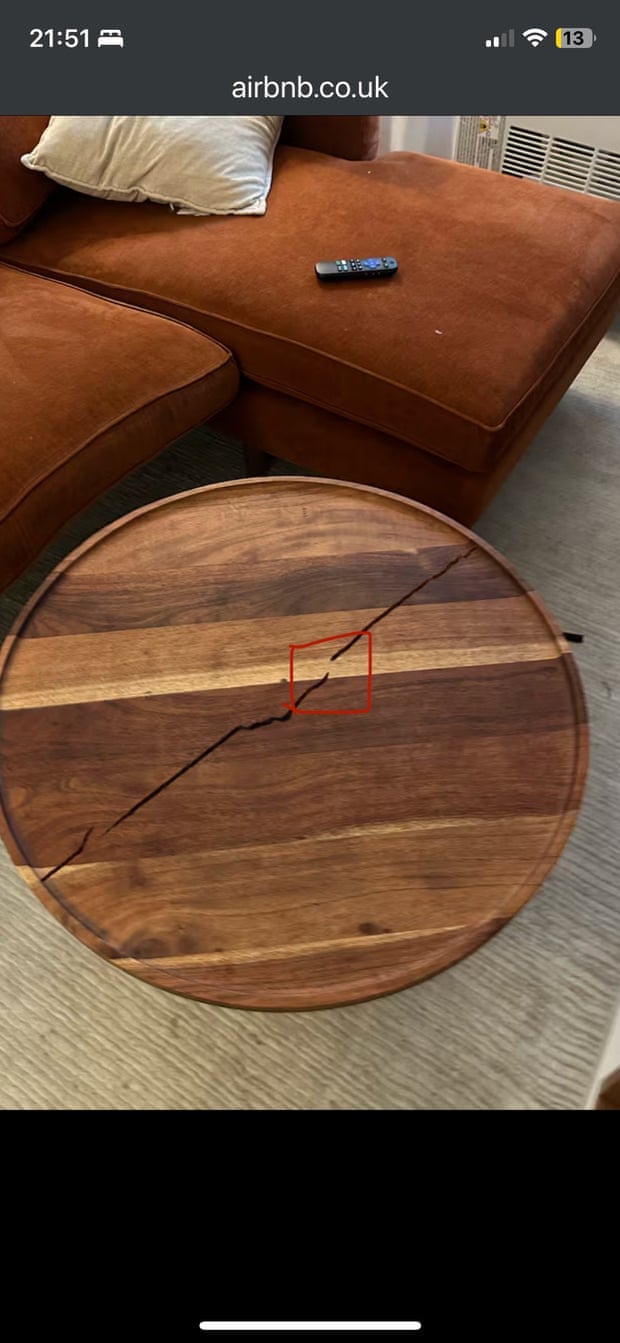 A photo of the coffee table with a crack that the host alleged was caused by the guest.