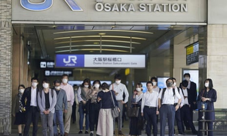 Commuters wearing protective masks head to work amid the coronavirus disease in Osaka.