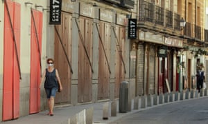 Une femme passe devant des restaurants fermés à Madrid