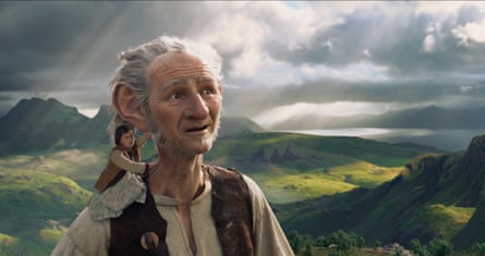 Movie still showing the BFG carrying Sophie on his shoulder through a hilly landscape with a cloudy horizon