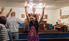 young woman raises hands in church