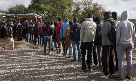 Refugees line up for food at the Calais camp.