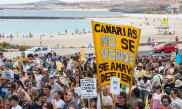 Crowds of protesters in front of a beach.