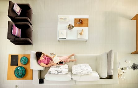 Top view of a woman reading a book while relaxing on a sofa in her living room at home
