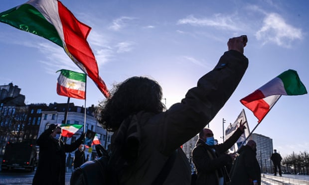 People gesture and wave former flags of Iran as they protest outside the Antwerp criminal court
