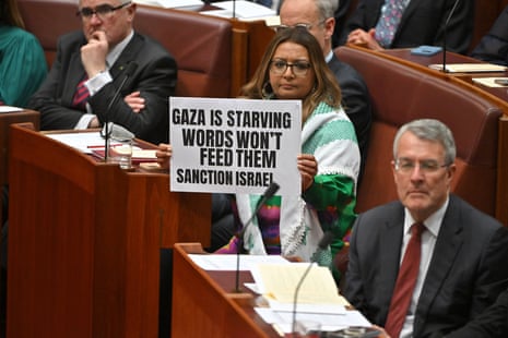Greens senator Mehreen Faruqi holds a sign in protest during governor-general Sam Mostyn’s speech in the Senate on Tuesday