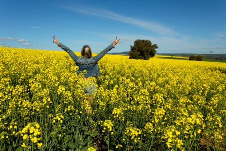 A girl in a field of canola flowers.