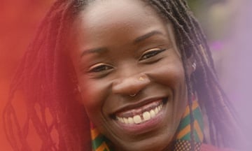 A young woman with dreadlocks and a gap-tooth smile grins widely.