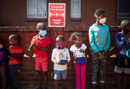Young children wait to receive food donations without their parents during a handout in Johannesburg.
