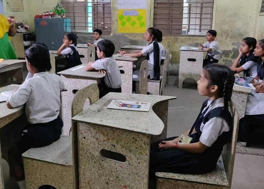 Schoolchildren sit in a classroom at desks and chairs made of recycled Tetra Pak cartons.