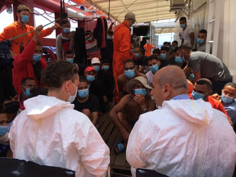 People rescued at sea sit on the deck of the ‘Ocean Viking’ rescue ship, jointly operated by French NGOs SOS Mediterranee and Medecins sans Frontieres (MSF Doctors without Borders) in the Mediterranean Sea on 4 July, 2020.