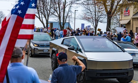 people with american flag give thumbs down to tesla cybertruck