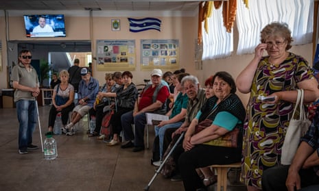 Kherson residents wait for food and water supplies at a depot in Kherson following the destruction of the Kakhovka dam.